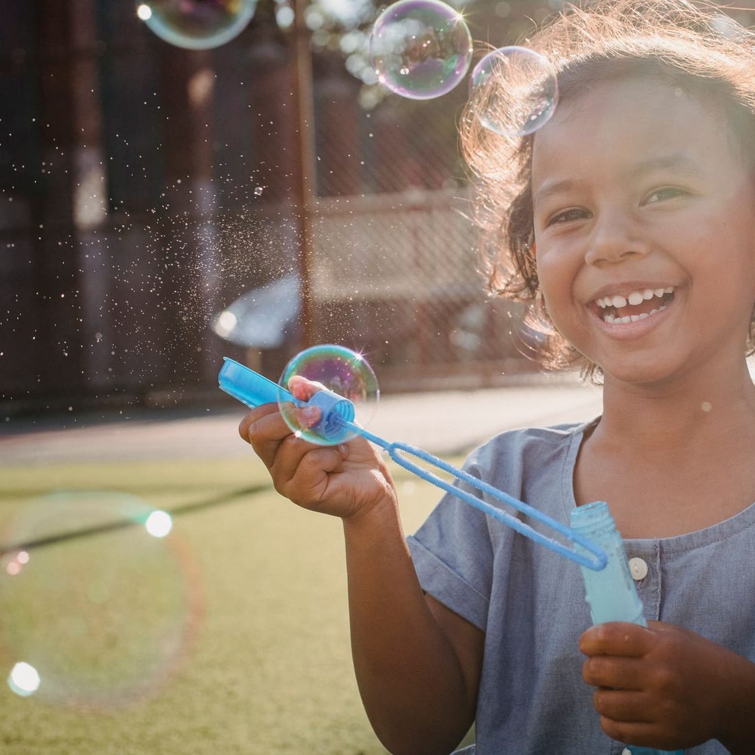 A child laughing while playing outdoors in warm afternoon light
